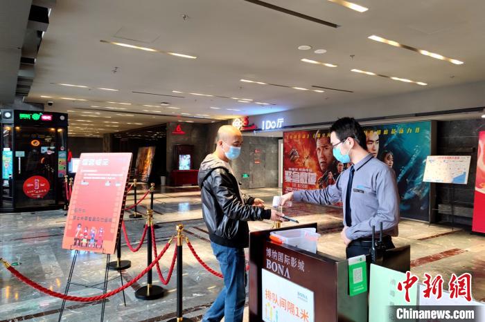 图为民众接受测温进入影院。梅镱泷 摄 图为民众接受测温进入影院。梅镱泷 摄